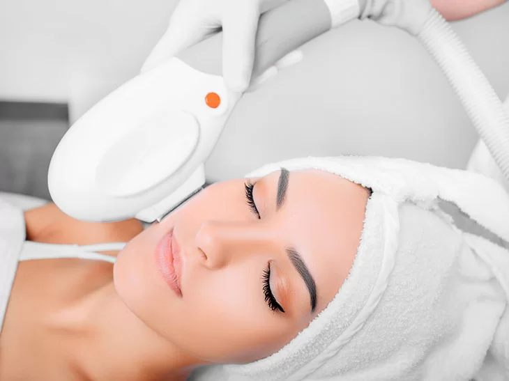 Mulher recebendo tratamento de laserterapia em consultório dermatológico com Dra. Sheila Matielo.